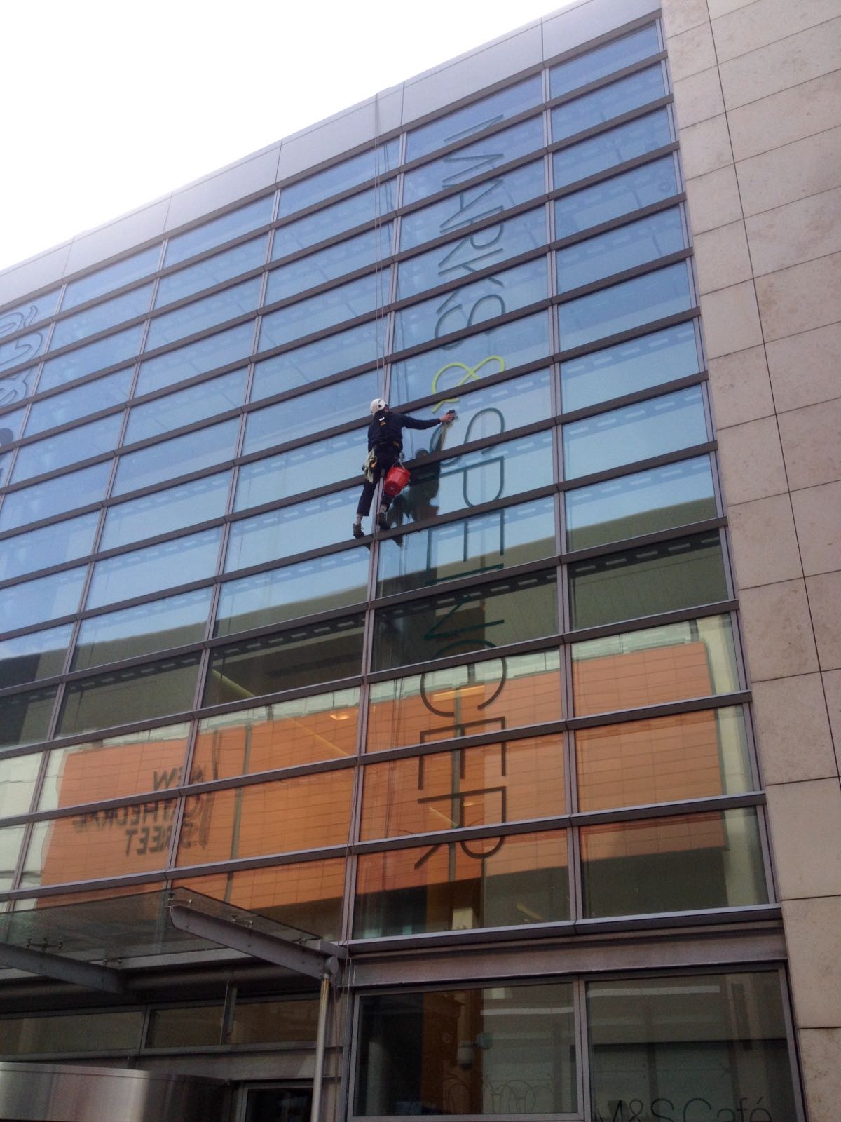 Window cleaning by abseiling